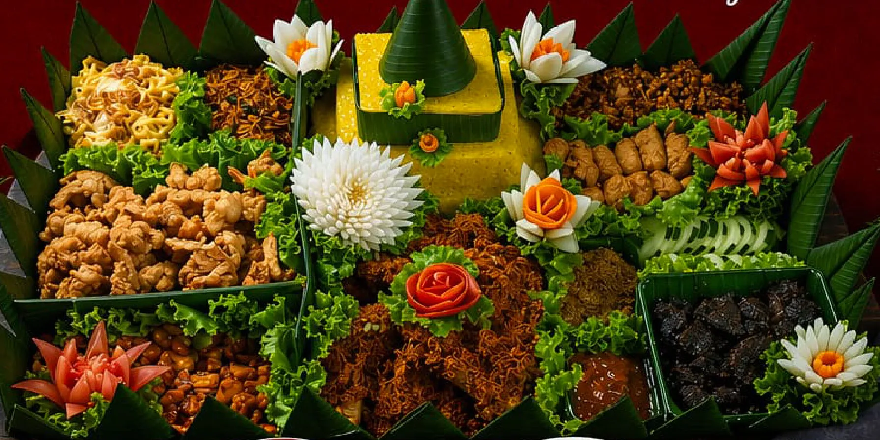Tumpeng Super Premium 20 orang: nasi kuning dikelilingi ayam suwir, mie goreng, sambal goreng ati, kacang dan ukiran sayur di atas tampah beralas daun pisang